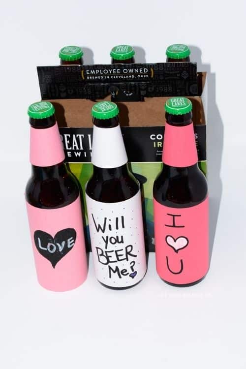 DIY Beer gift that is a six pack of beer that has written love messages on it.