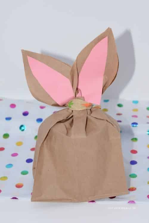 Create the easter bunny paper treat bags by adding the pink construction paper and ribbon to complete it.