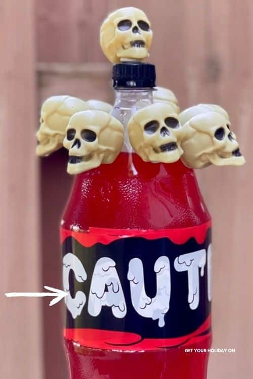 Using caution tape from the dollar store wrap it around the 2-liter bottle a few times to prevent the label from showing through on the dollar tree skull DIY!