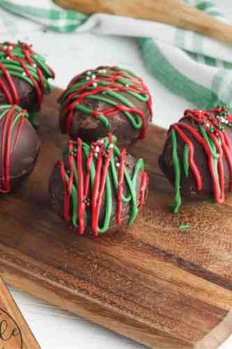 Stuffed chocolate balls with red and green chocolate icing and sprinkles on top.