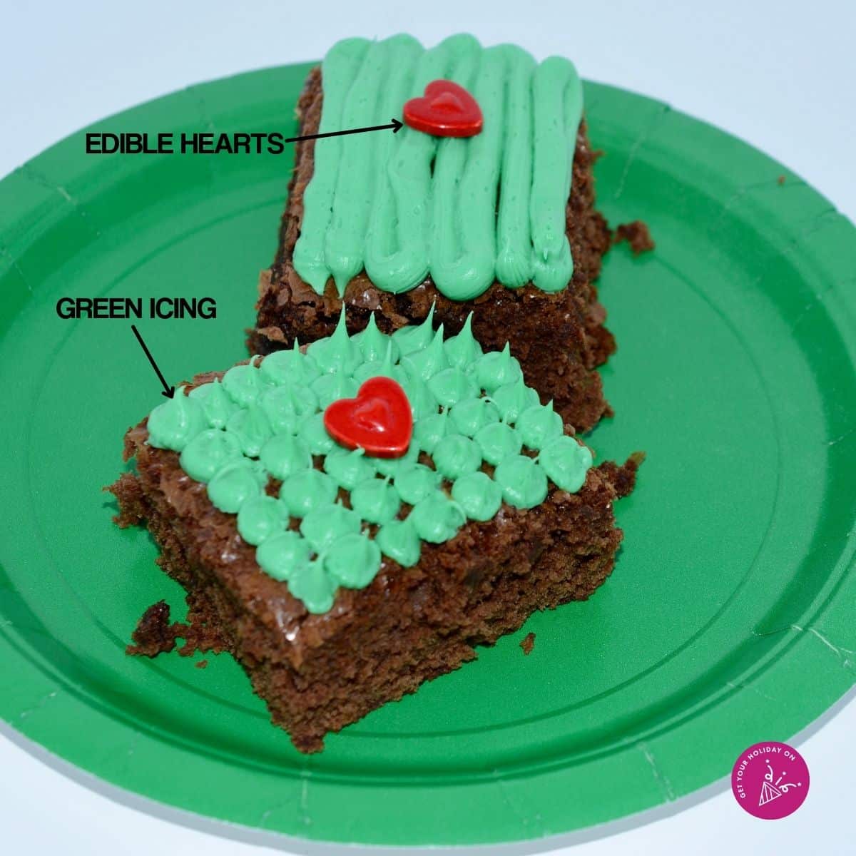 Green icing on top of the brownie and edible red hearts to complete the Grinch brownie.