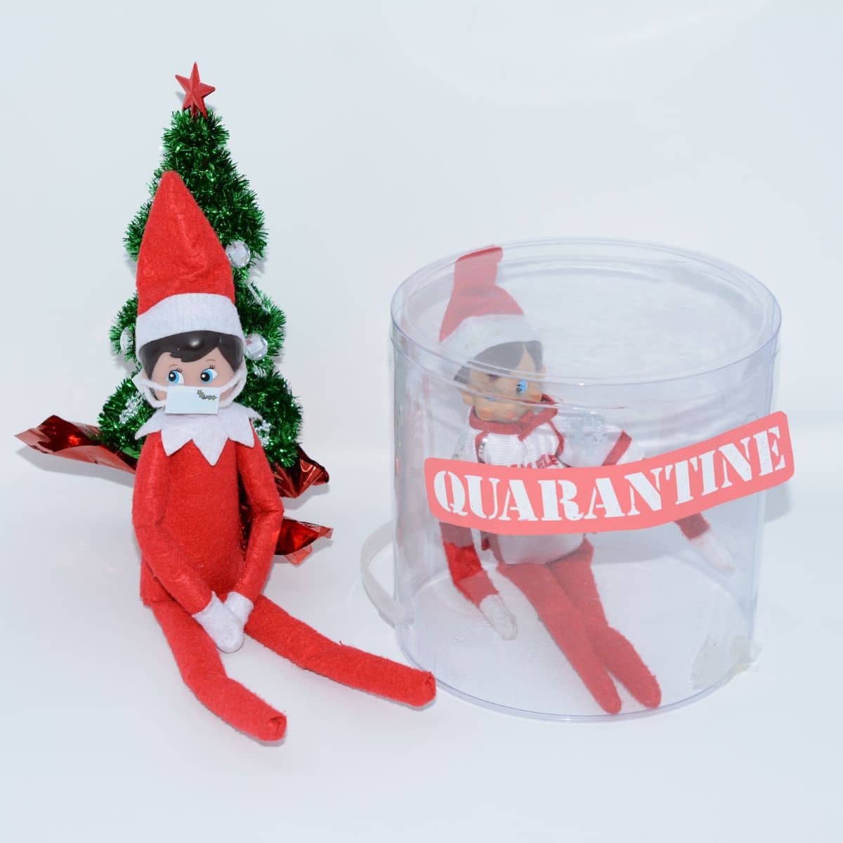 Elf sitting by Christmas tree and wearing a mask another elf inside quarantine examples from going through covid 2020 elf on the shelf.