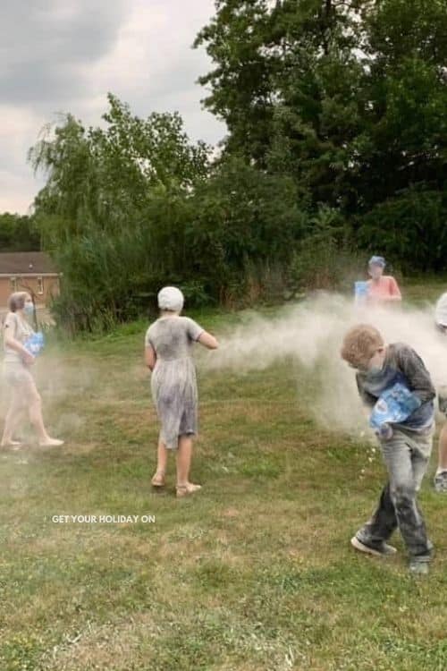 Teenagers having flour fights in the backyard of our church outside for large group bible games.