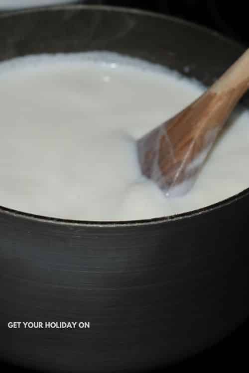 diy hot cocoa bombs Warming milk in a pot on the stove for this drink.