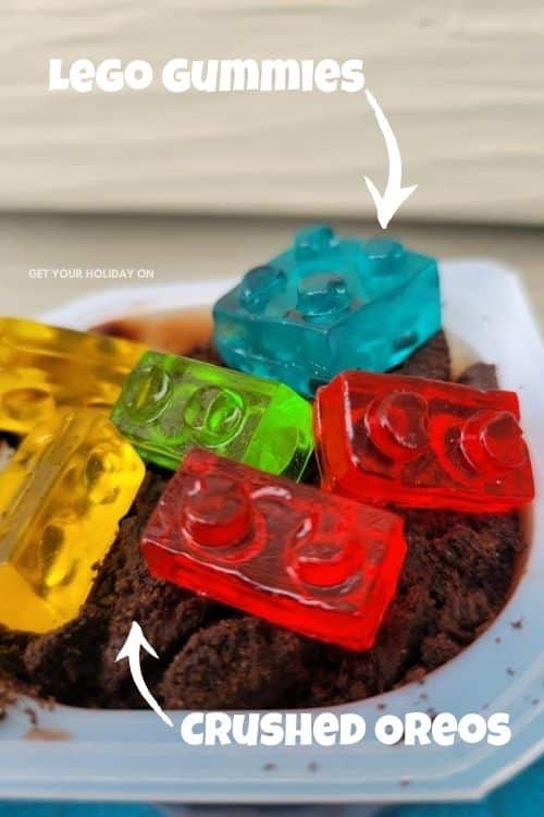 Lego gummies and crushed Oreos put into a dirt cup dessert.