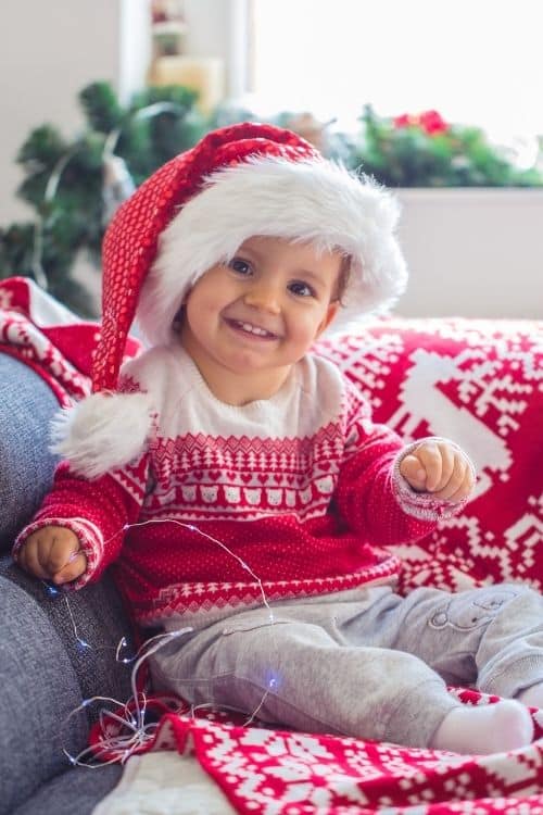 Boy dressed up like Santa with a hat on to start the game at his holiday party.