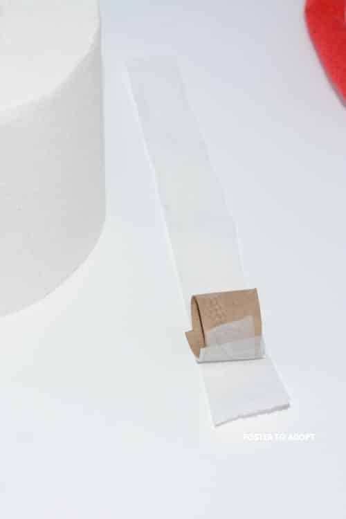 toilet paper being wrapped around the mini toilet cardboard holder.