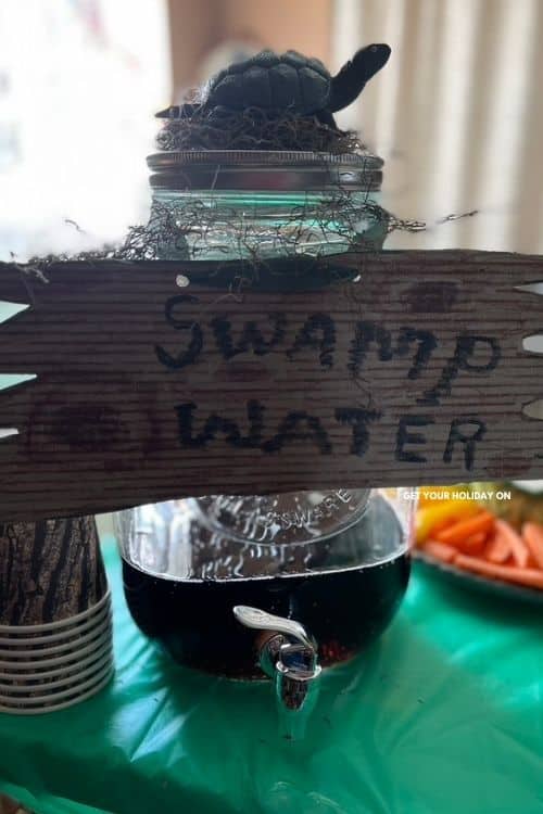 Root beer turned into swamp water drink and decorated with Spanish moss and a turtle on top.