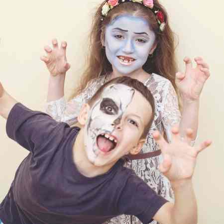 Two people that are dressed up as zombies to play zombie tag.